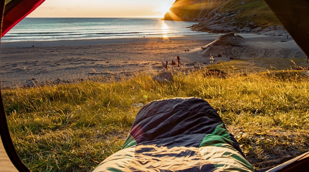 Camping on the Beach at Sunset. Spectacular sunset view to rugged mountain peaks above Kvalvika - famous surfing beach at Lofoten islands, Norway. Lifestyle summer journey vacations