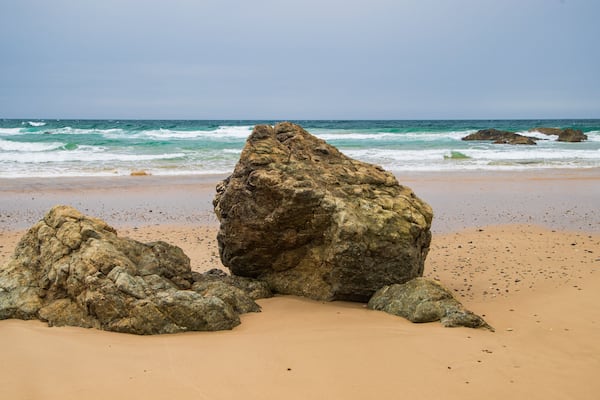 Oxley Beach which includes general coastal views, rocky coastline and a sandy beach