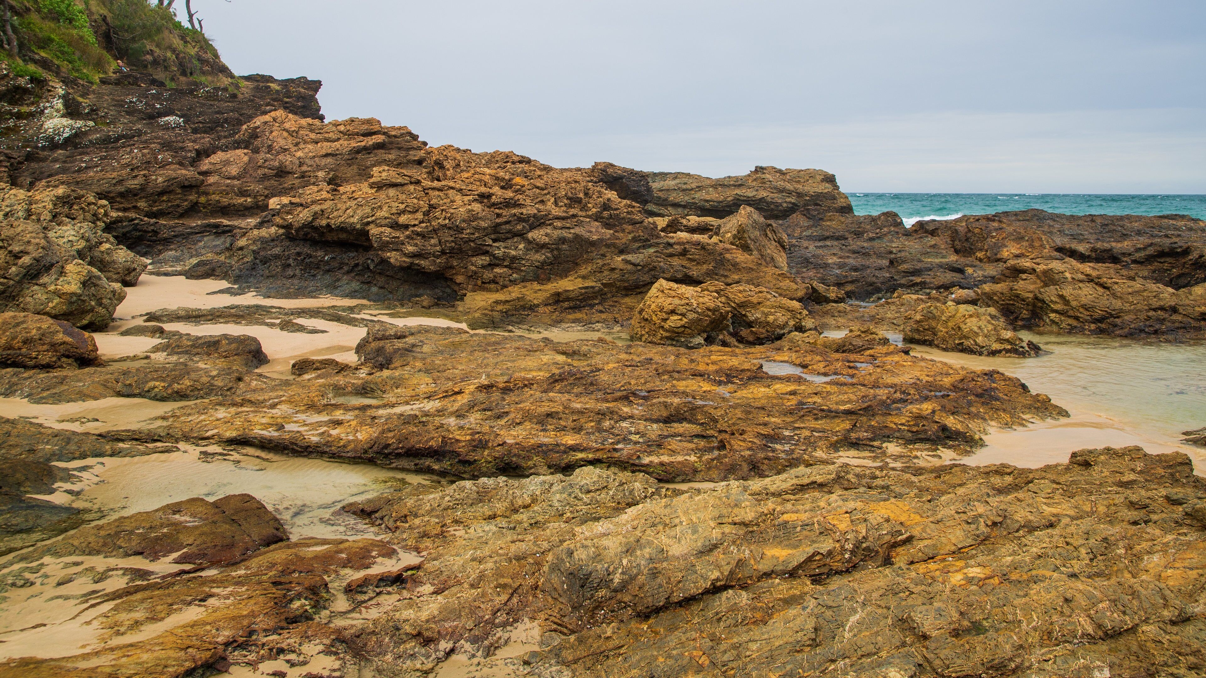 Oxley Beach showing a sandy beach, general coastal views and rocky coastline