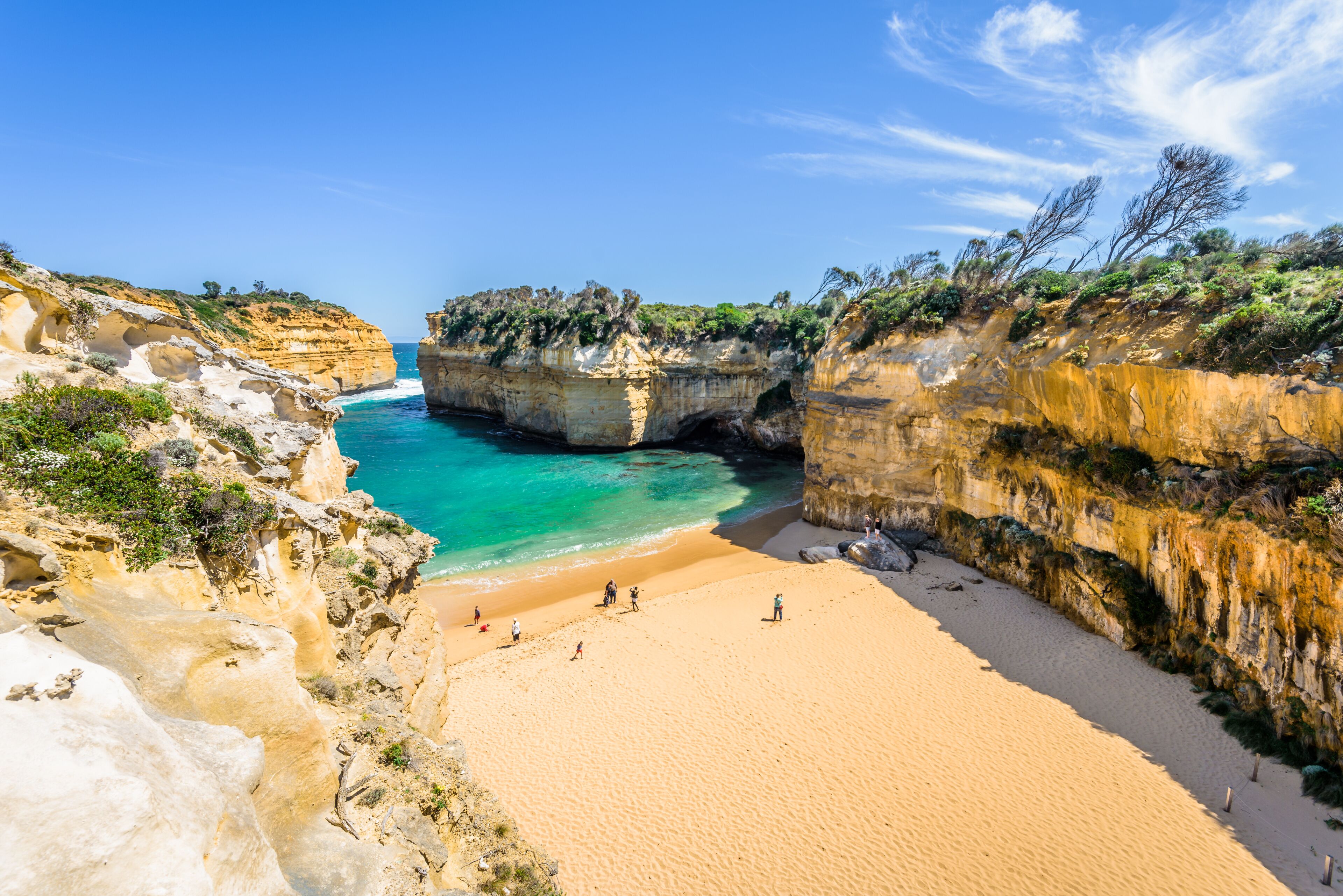 Bright sunny summer coast view to a beautiful sandy beach bay and rocky erosion sand limestone cliff of Great Ocean Road, walking at Loch Ard Gorge, Port Campbell National Park, Victoria/ Australia