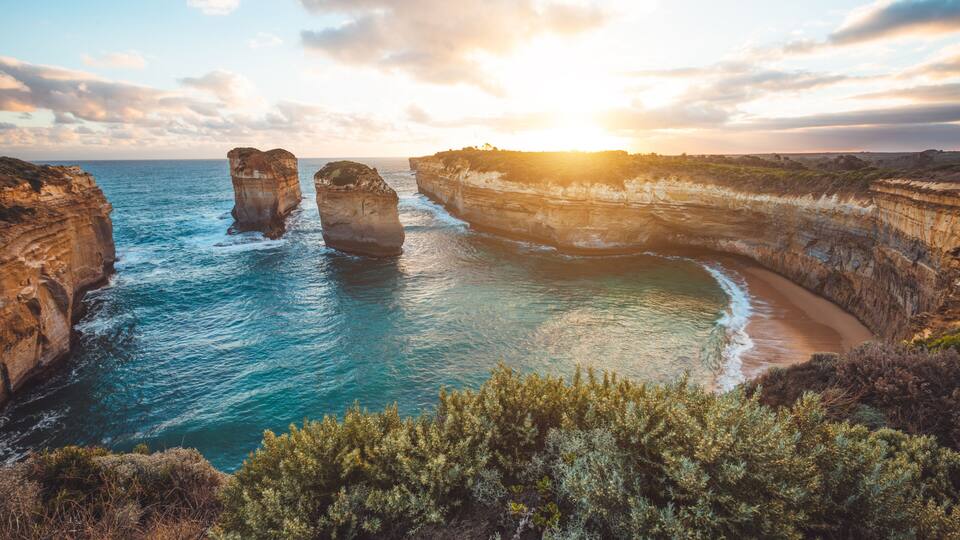 A coastal landscape with rock formations and a beach.