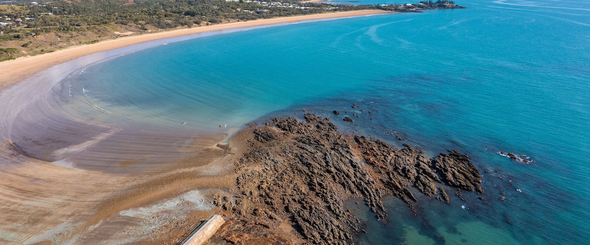 Emu Park Main Beach which includes rugged coastline, general coastal views and landscape views