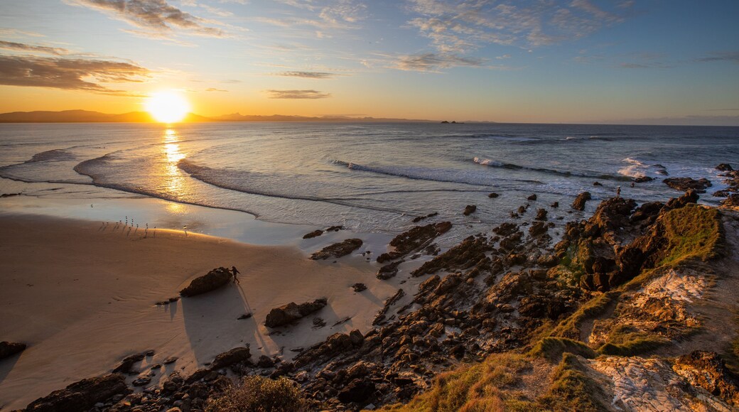 Little Wategos Beach showing rocky coastline, a sunset and a beach