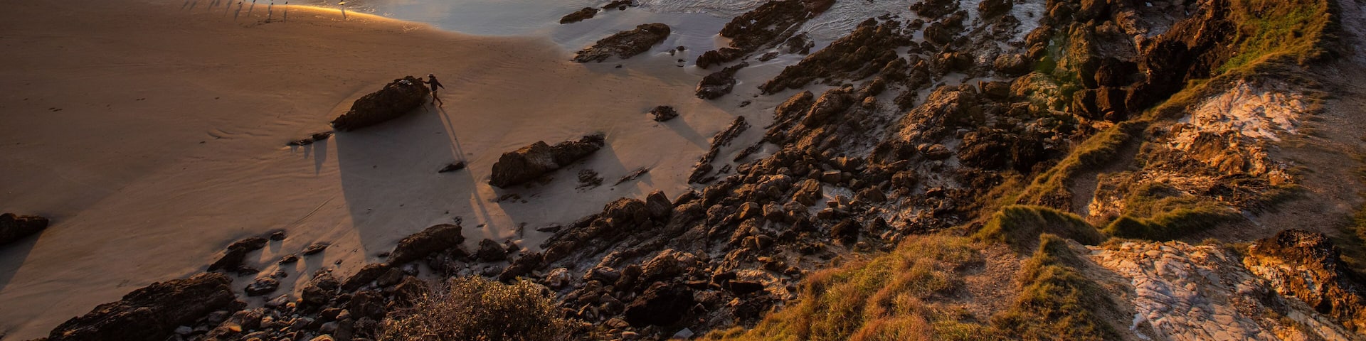 Little Wategos Beach showing rocky coastline, a sunset and a beach