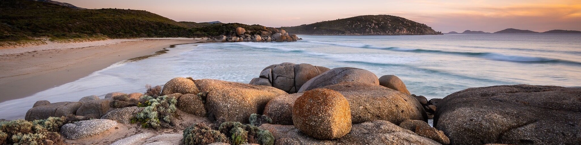 Costa rocosa con olas al atardecer.