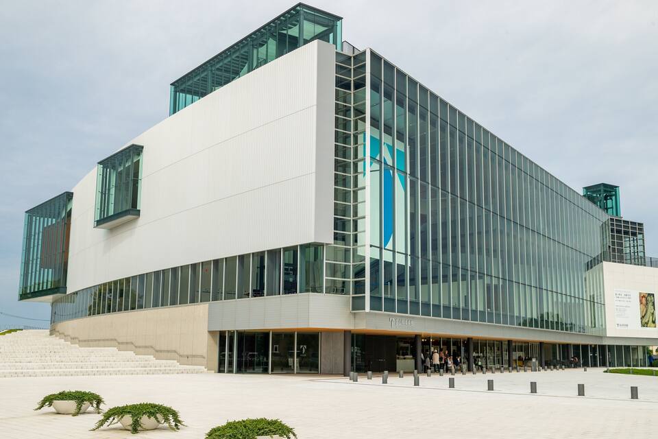 A modern building with large glass windows and a white facade.