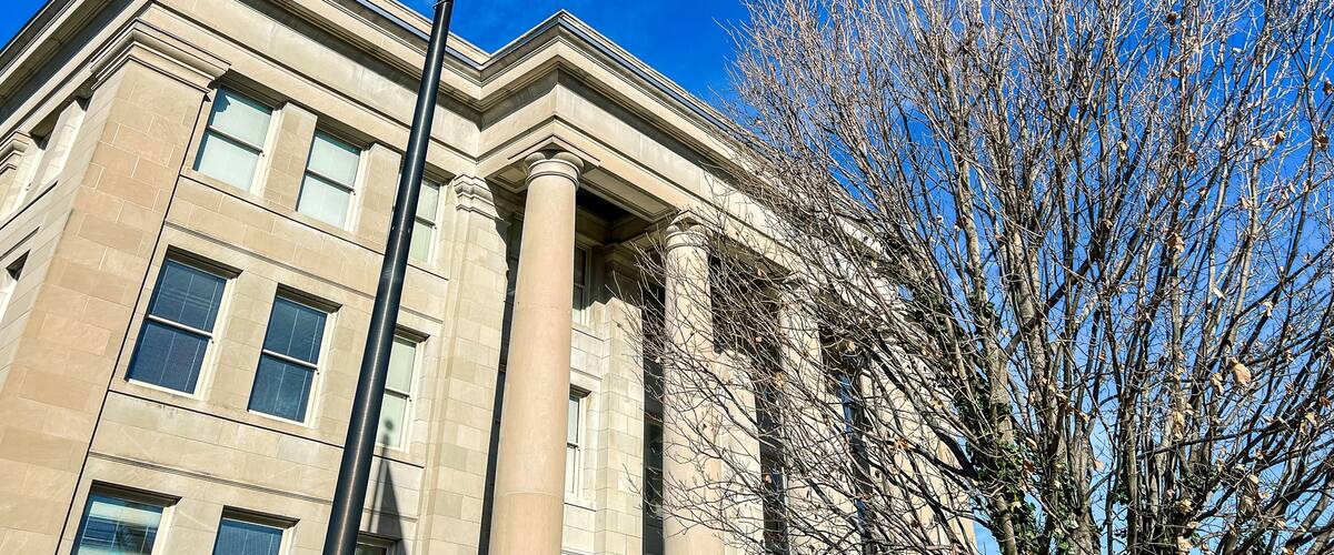 Exterior Views of the Appellate Court of the State of Illinois Fourth District Building in Springfield, Illinois, USA. American and State of Illinois Flags fly in the forefront of view.