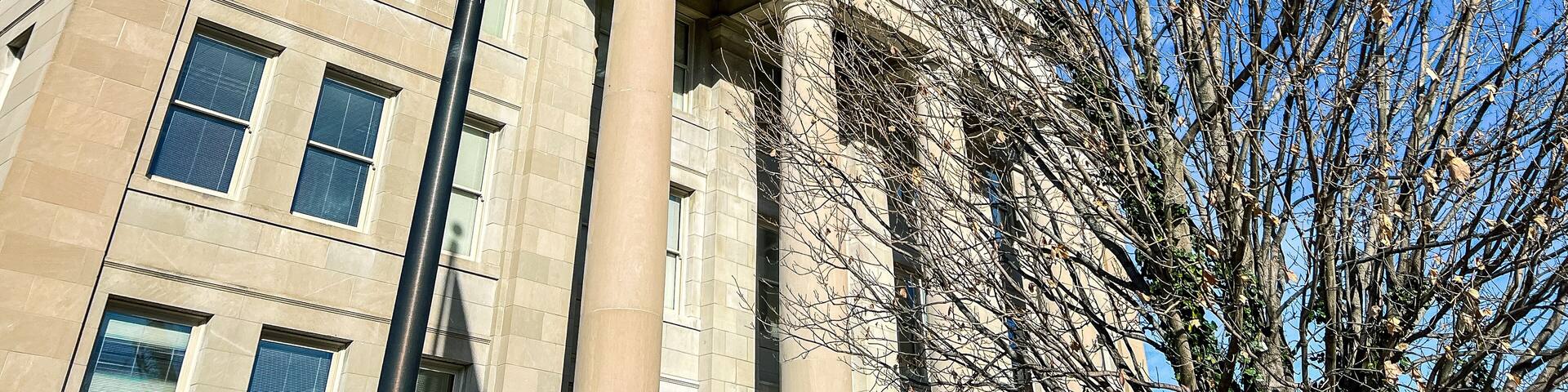 Exterior Views of the Appellate Court of the State of Illinois Fourth District Building in Springfield, Illinois, USA. American and State of Illinois Flags fly in the forefront of view.