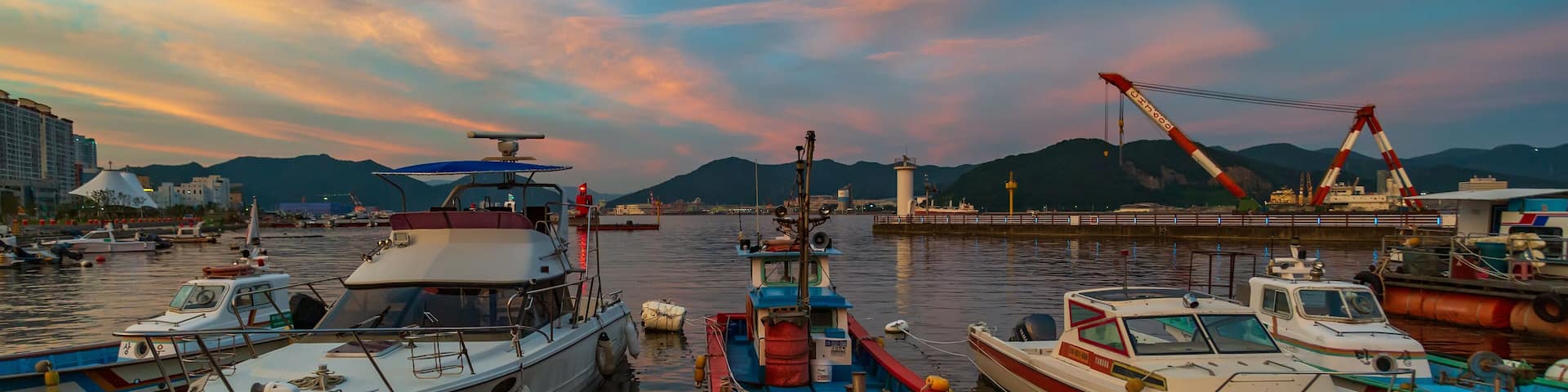 The sunset view of Masan Port in Changwon, South Gyeongsang Province, South Korea, where meat boats are anchored at the mooring.