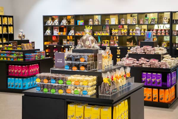 Une chocolaterie où l’on peut trouver une variété de produits au chocolat, présentés sur des étagères et des comptoirs.