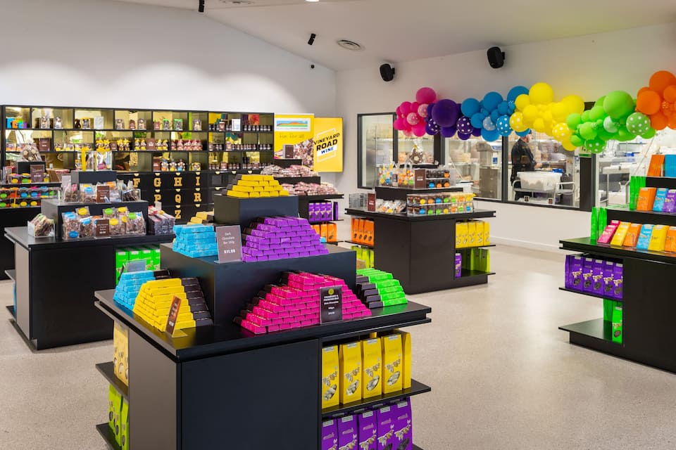 Una tienda de dulces con exhibiciones coloridas y globos.