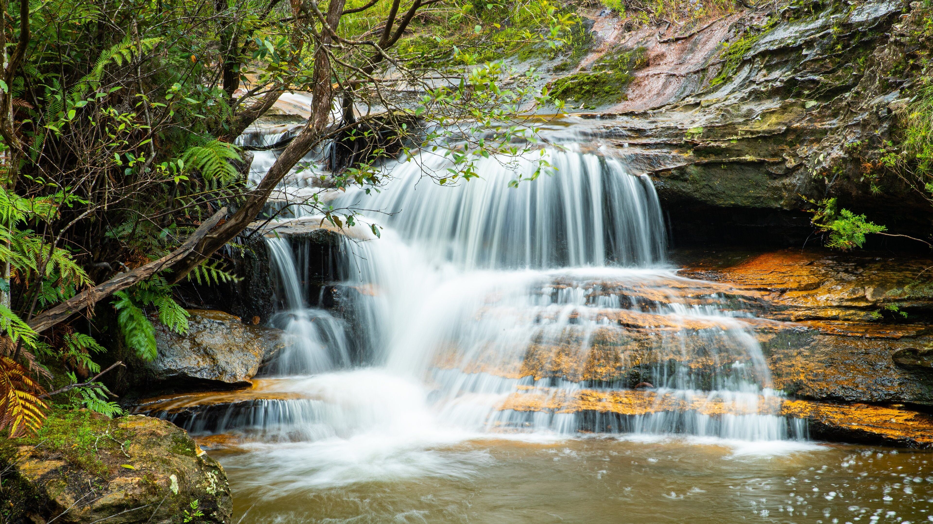 A waterfall cascading over rocks in a forested area.