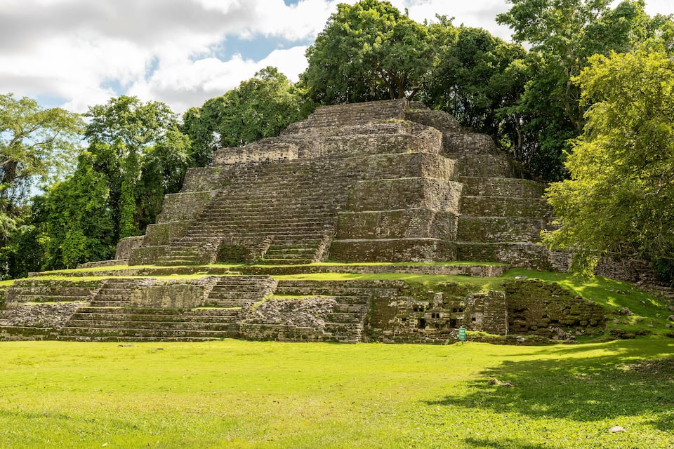 A large stone pyramid surrounded by lush green trees.