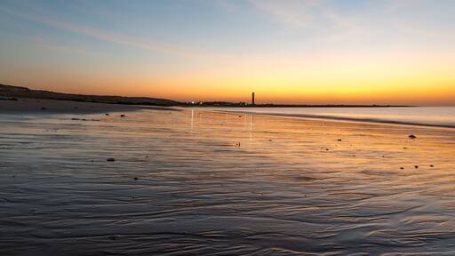 Dusk shot at Shivrajpur beach gujarat India with cloudy sky and reflection in waves