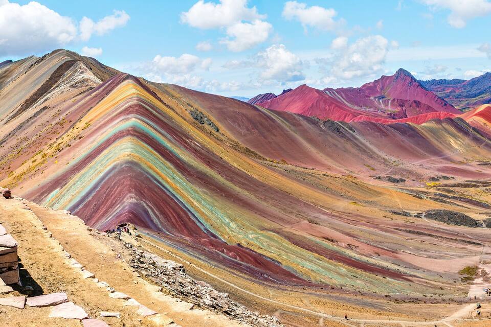 A colorful mountain range with layered rock formations and a clear sky.