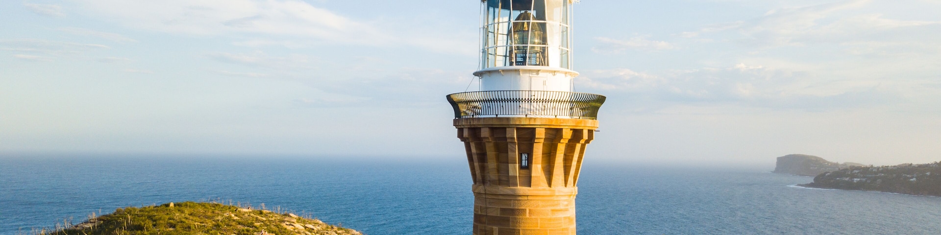 Hill top of Barrenjoey head of Sydney Pacific coast with the lighthouse overlooking palm beach on a sunny day.