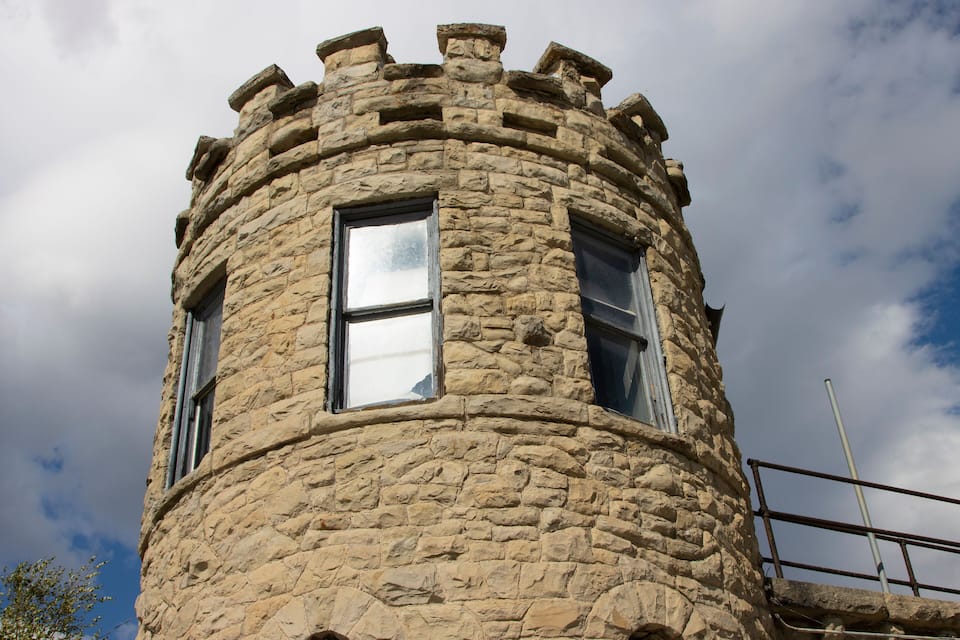 A stone tower with a rounded top and windows.