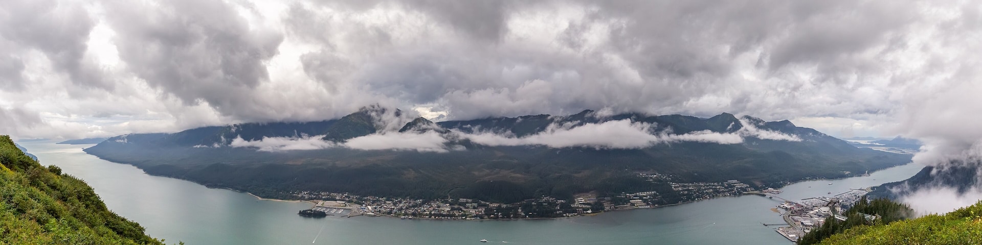 Panoramic view of Gastineau Channel, port of Juneau and mountains covered with clouds from the top of mountain Roberts in Alaska