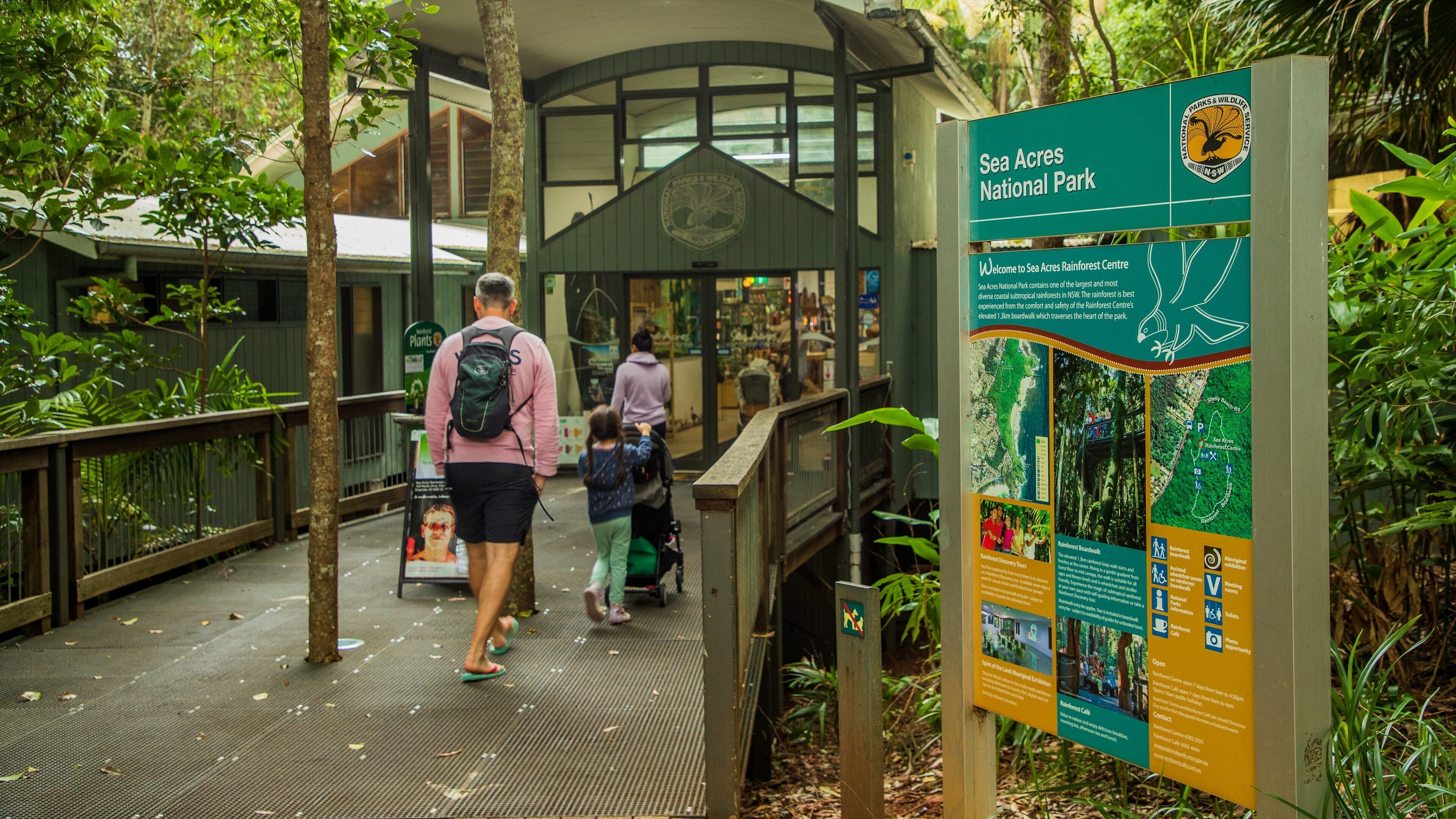 Sea Acres National Park featuring signage as well as a family