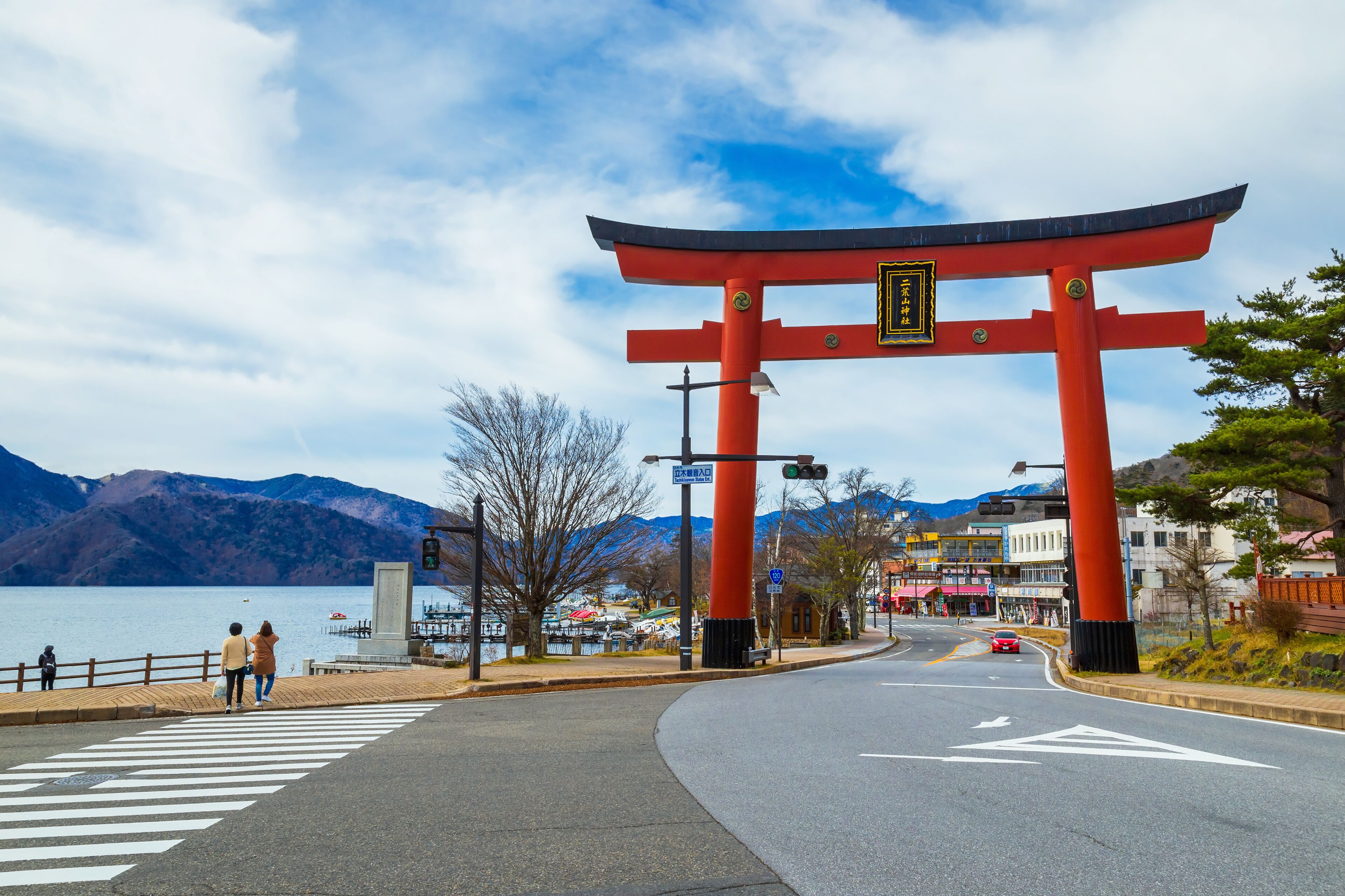 Massive torii gate of Futarasan shrine in front of lake Chuzenji in Nikko, Japan