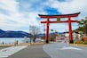 Massive torii gate of Futarasan shrine in front of lake Chuzenji in Nikko, Japan