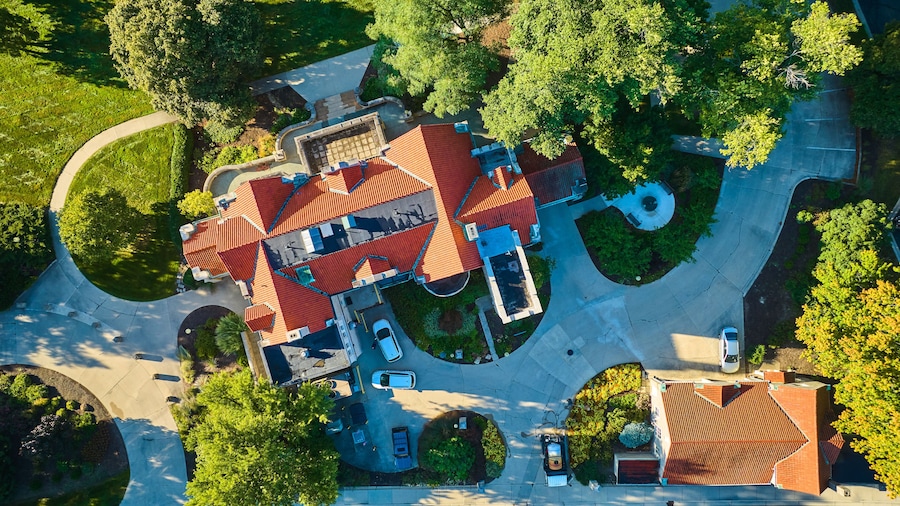 Aerial above Minnetrista Museum and Gardens mansion building with winding path on sunny day