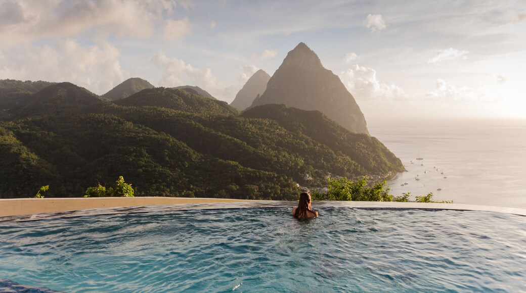 Frau genießt den wunderschönen Ausblick auf die Pitons im Infinitypool Entspannung pur