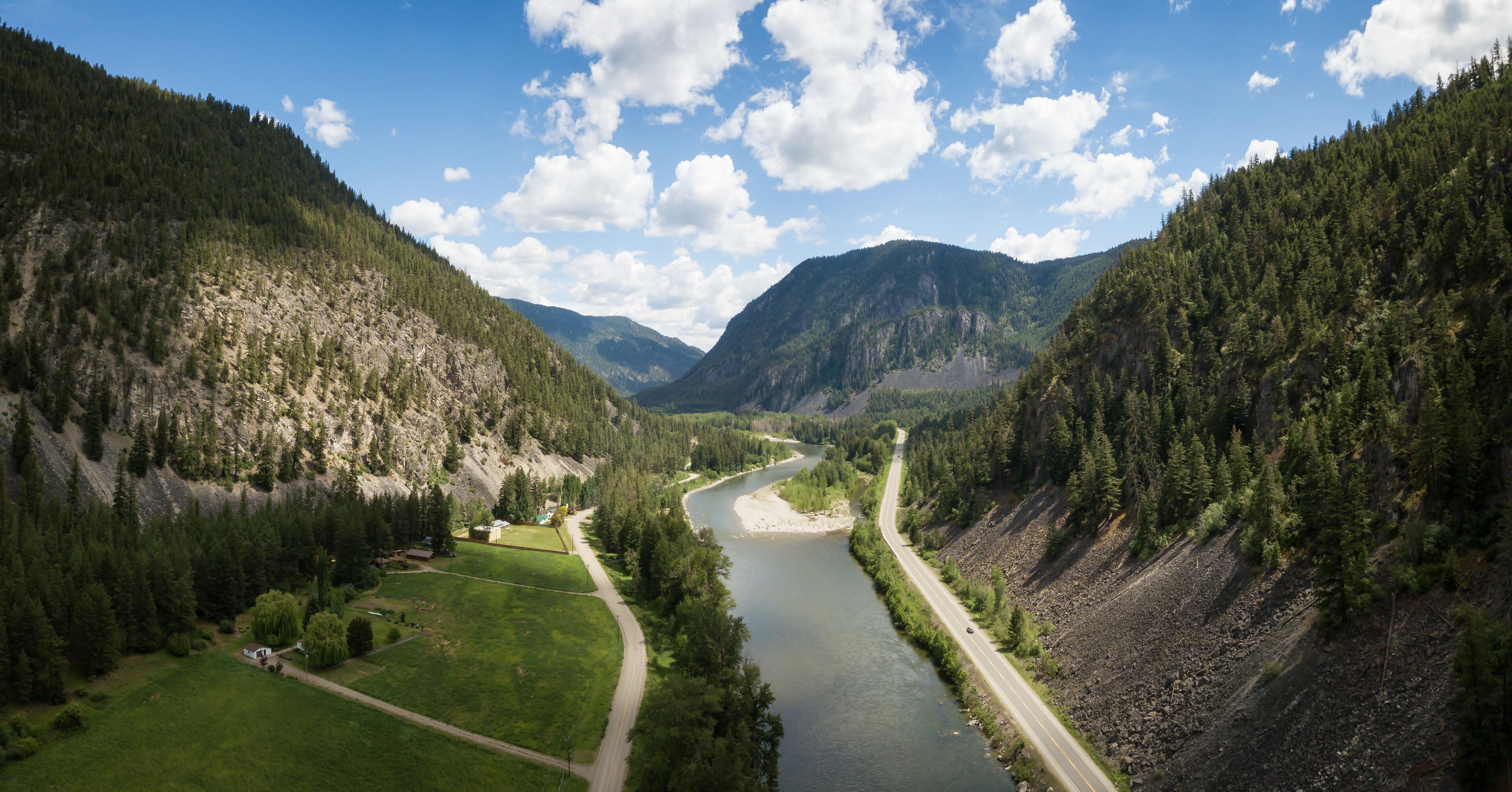 Aerial panoramic view of a scenic road going through the valley surrounded by the Beautiful Canadian Mountains. Located between Hope and Princeton, BC, Canada.