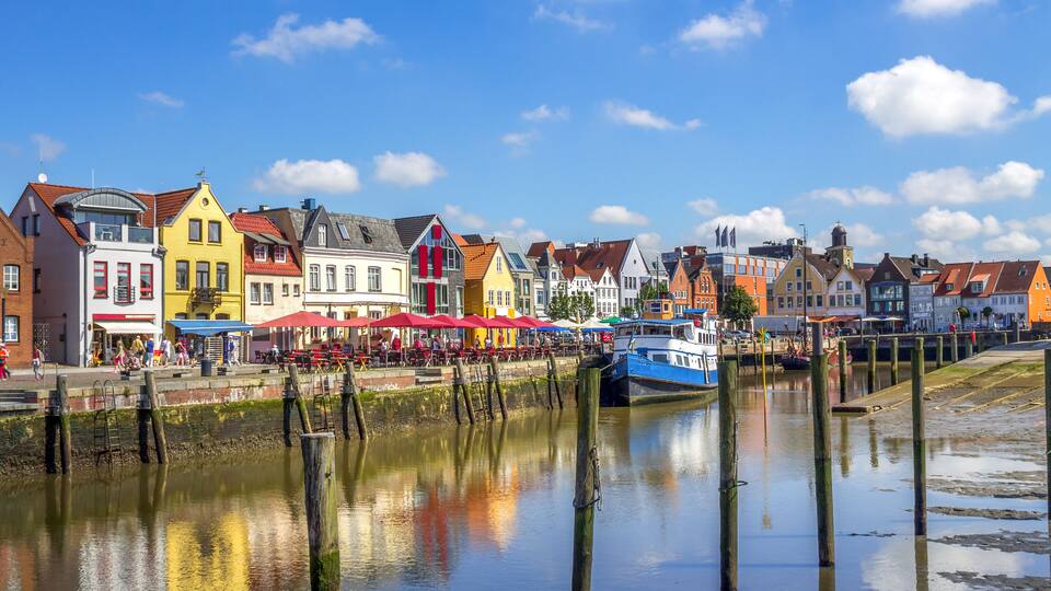 A canal with colorful buildings and a boat docked on the right.