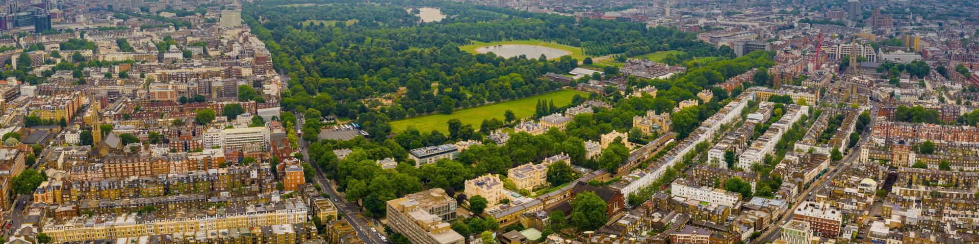 Beautiful aerial view of the Hyde park in London, UK. Magical sunset view over the park with London skyline on the horizon.