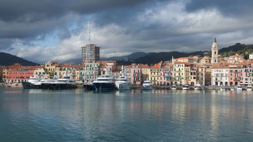 A harbor with boats, colorful buildings, and a tower.