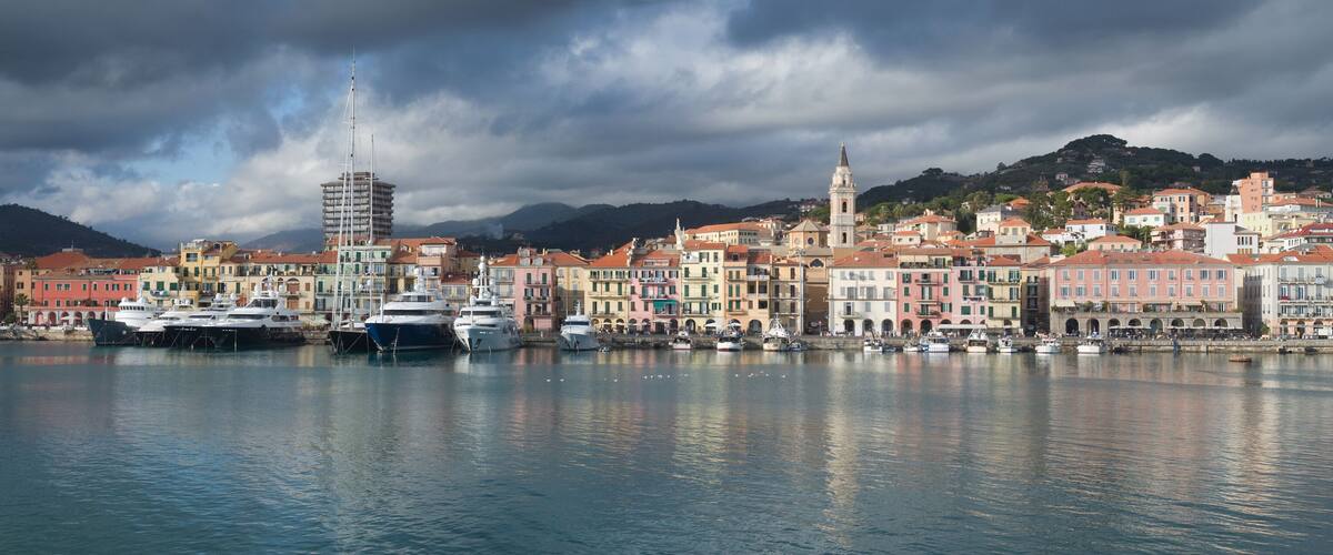 A harbor with boats, colorful buildings, and a tower.