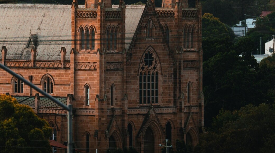 A historic brick St. Mary’s Catholic Church in Ipswich, Australia, featuring classic Gothic-style architecture, tall spires, and arched windows under a clear sky.