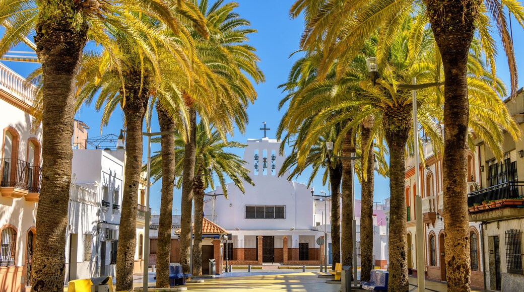 View of Jesus del Gran Poder church and picturesque Walk of Palms plaza in old town Isla Cristina, Huelva, Spain