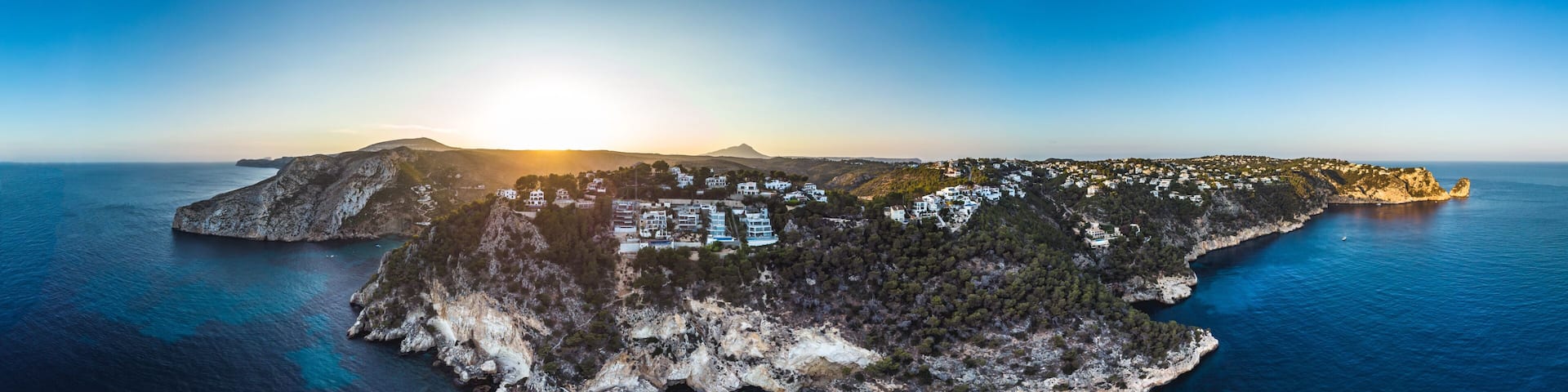 Arial drone view on Granadella beach sheltered between two rocky headlands in the province of Alicante, Valencia, Spain, Xabia, Javea, back side of the Montgo summer 2018. Golden hour sunset and pines