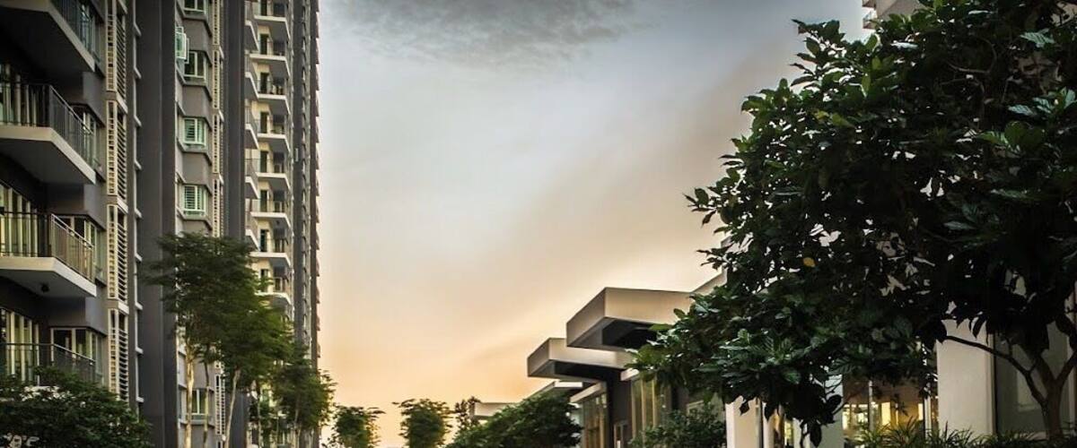 A modern urban courtyard with geometric paving, wooden benches, and high-rise residential buildings.