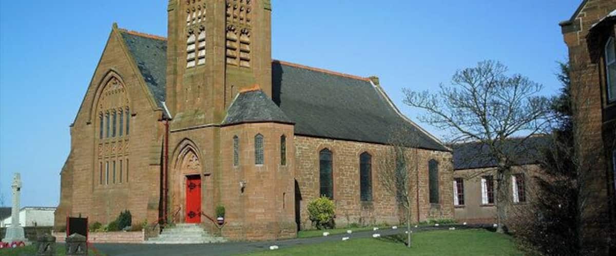 A historic church with a prominent clock tower and a red door.