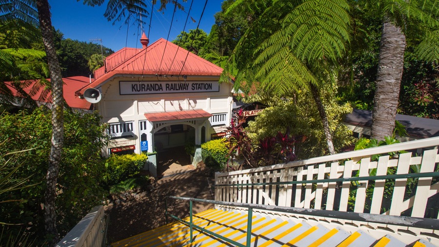 Un bâtiment de gare avec un toit rouge et une enseigne indiquant « GARE DE KURANDA ».