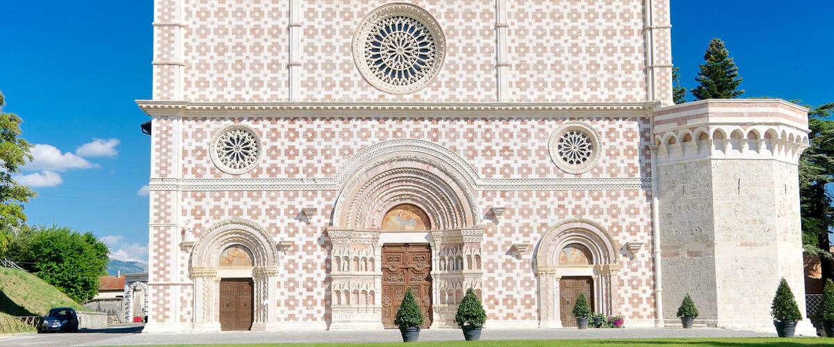 A large building with a patterned facade, arched doorways, and a central circular window.