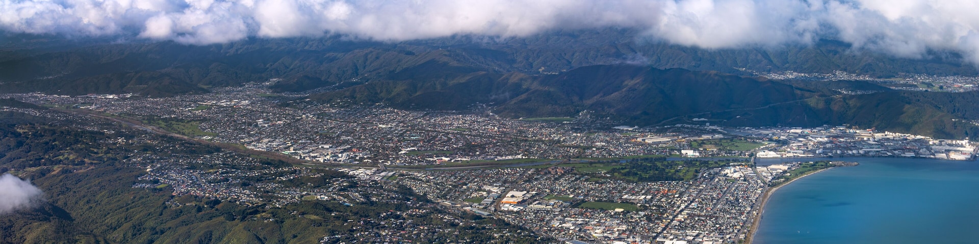 Lower Hutt, Wellington, New Zealand. Panoramic aerial view. Hutt River flows out to sea above Petone Beach at far right. Wainuiomata over the hill at top right.