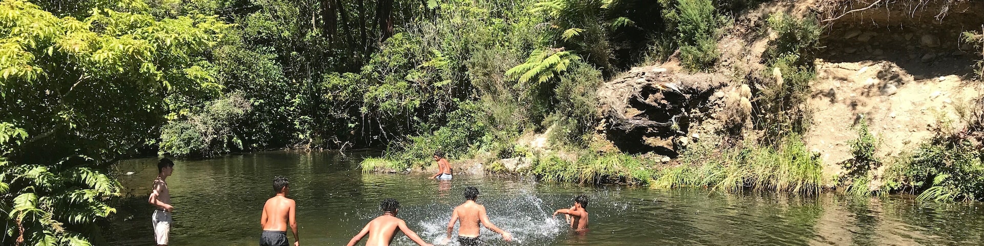 Maori children enjoying a pretty & secluded spot off the main path of Wainuiomata Recreation area, Wellington, New Zealand