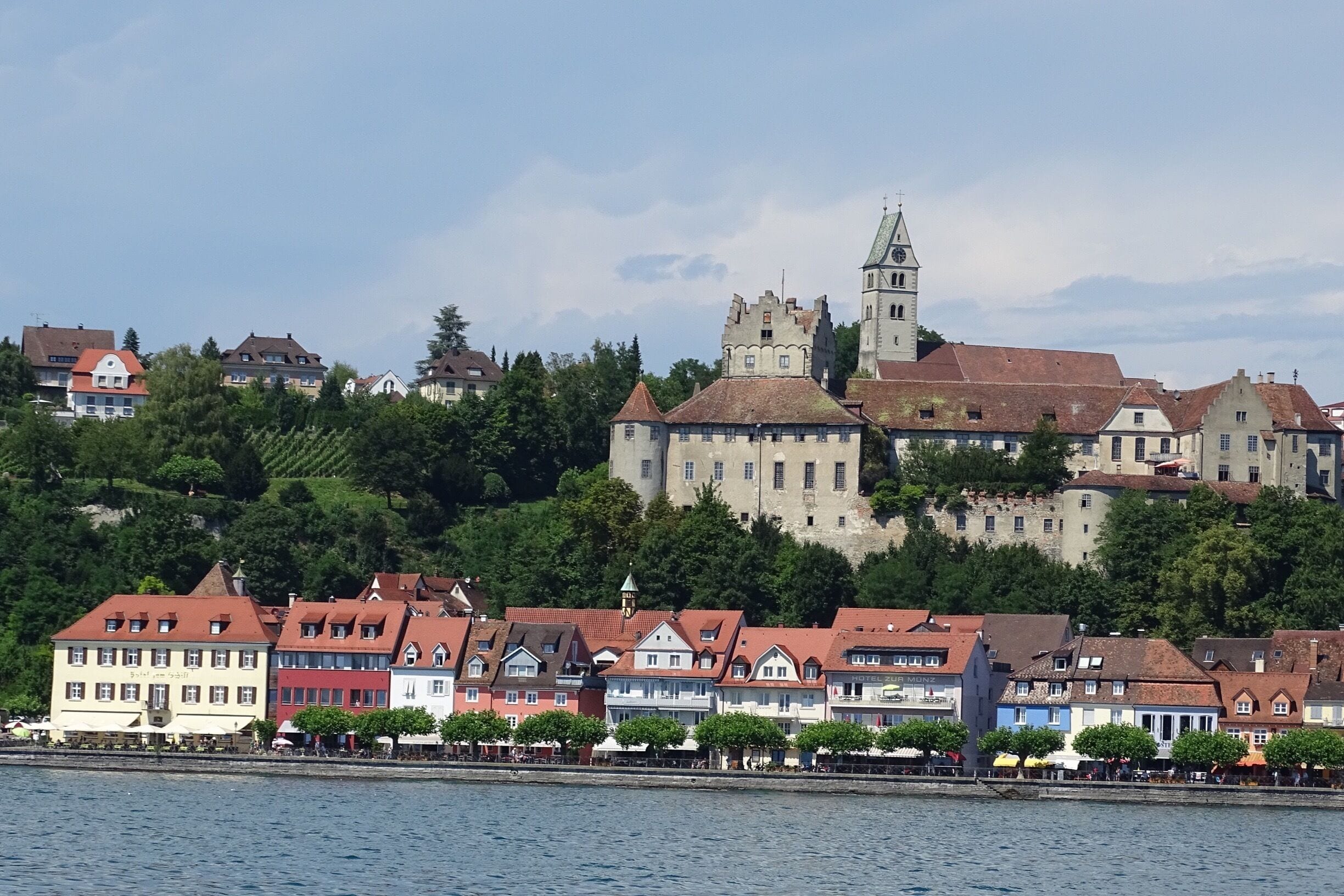 A town with colorful buildings and a castle on a hill.