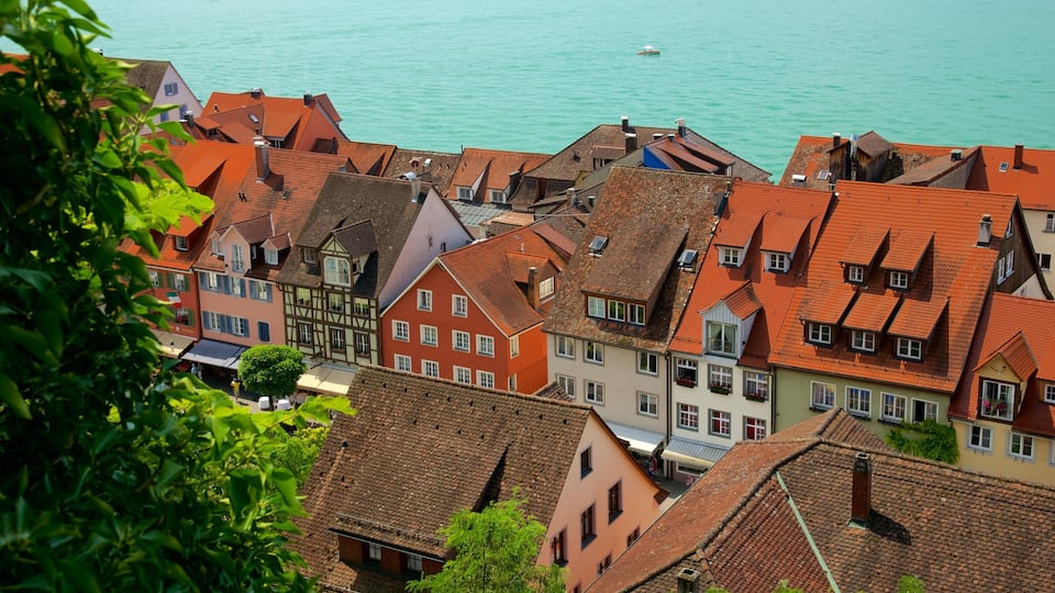 A coastal town with red-tiled roofs and a turquoise sea.