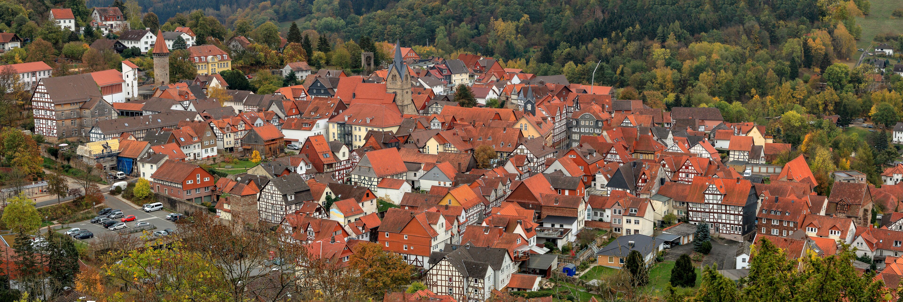 A densely packed village with red-roofed houses and a prominent church tower.