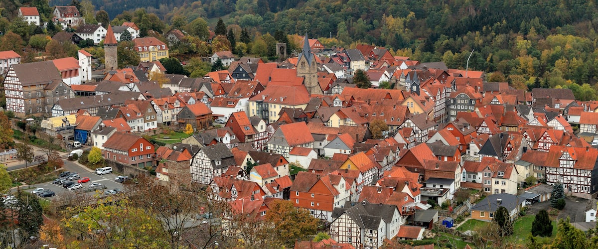 A densely packed village with red-roofed houses and a prominent church tower.