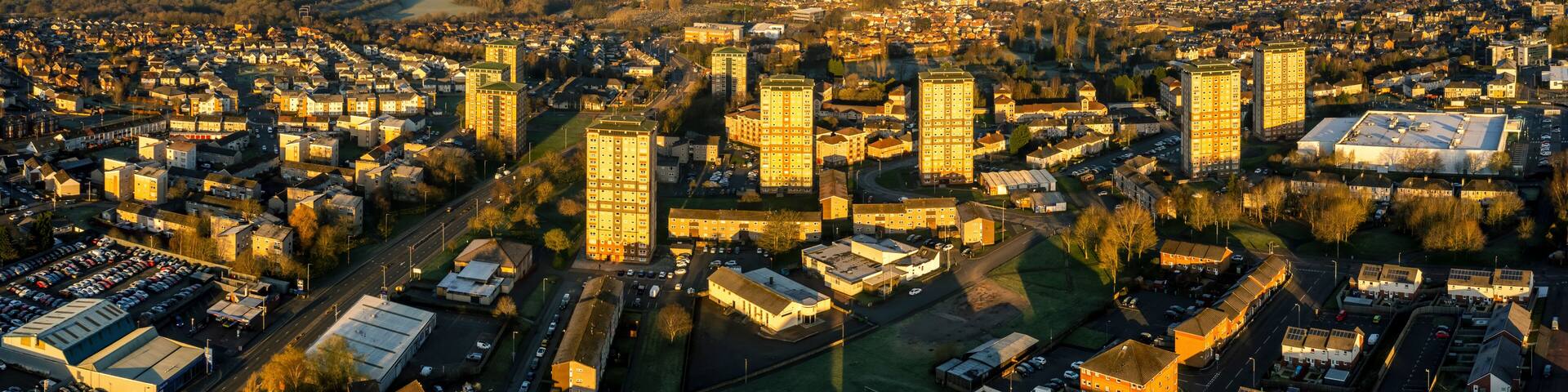 Aerial view of residential neighborhood with river, roads, and trees at sunset, Watsonville, Motherwell, United Kingdom.
