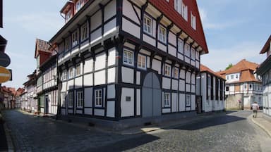 A traditional half-timbered building with a red roof and white walls, located on a cobblestone street.