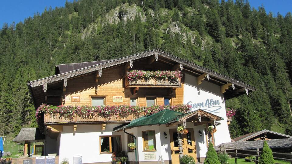 A traditional wooden building with flower boxes and a sign that reads "Zimmer BELEOT."