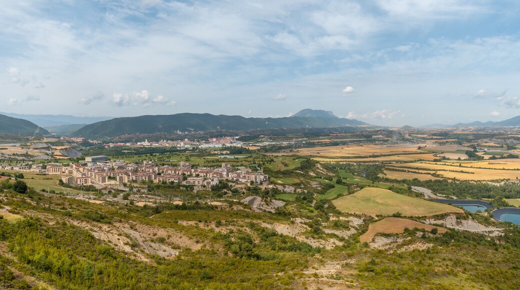 A town nestled in a valley with mountains in the background.