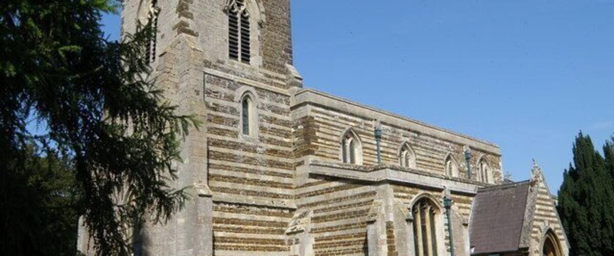 A historic stone church with a tower and arched windows.